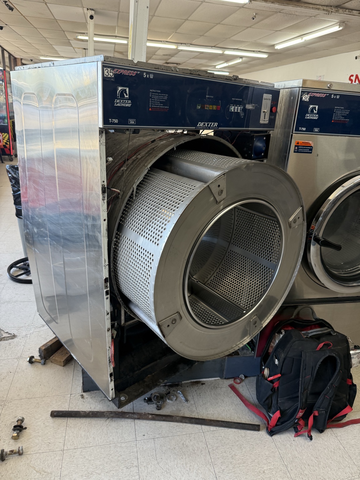 Dexter commercial washer opened for repair with its basket partially removed